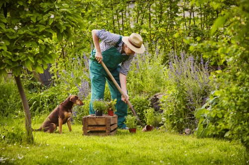 Gardener sorting green waste into compost and wood chip bins in Marylebone